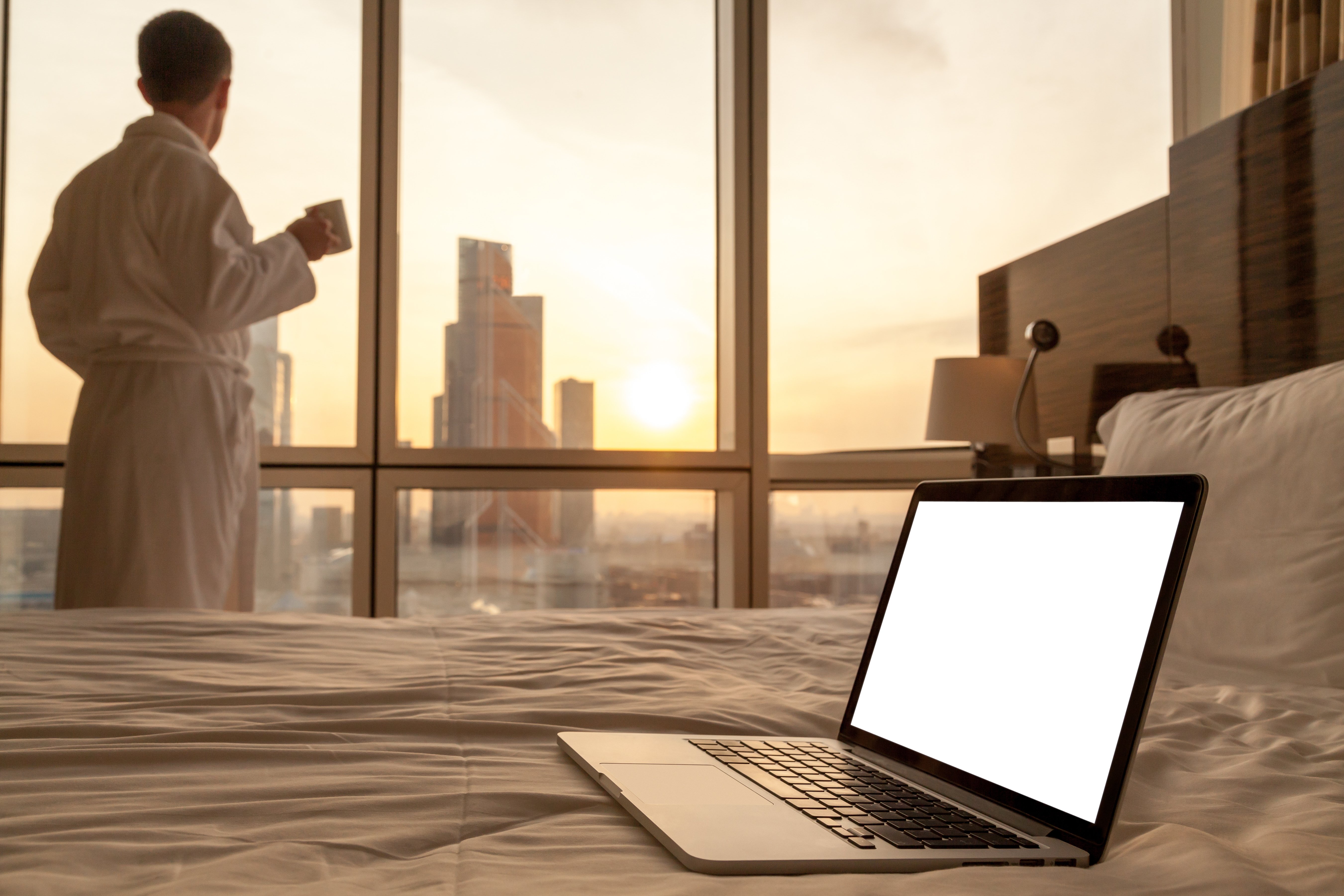 close-up-laptop-bed-with-man-bathrobe-background