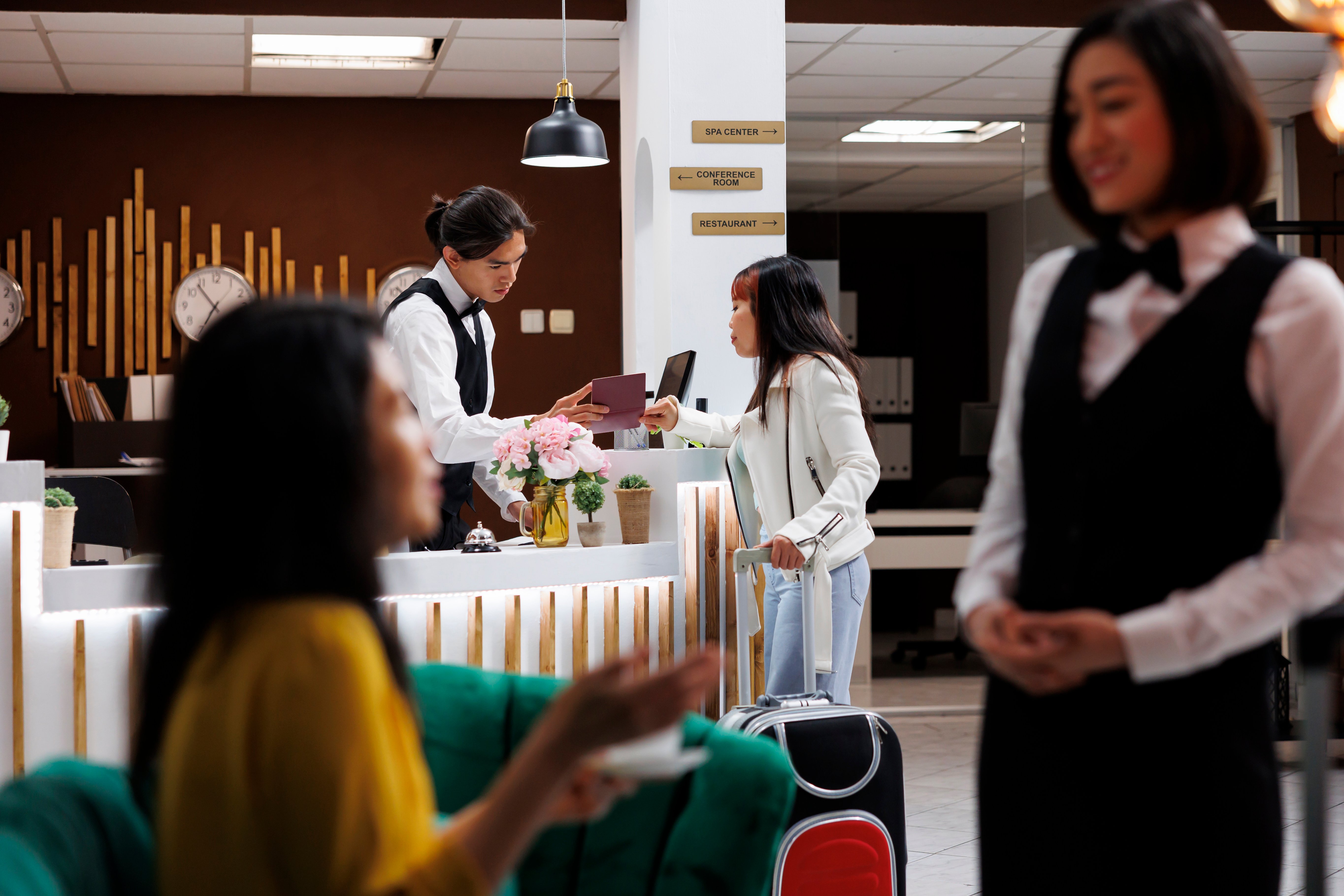 male-front-desk-receptionist-luxury-resort-checking-visitors-passports-before-registration-asian-visitor-sipping-coffee-modern-waiting-lounge-ready-make-reservation-modern-hotel